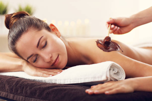 picture of beautiful woman getting chocolate massage in spa