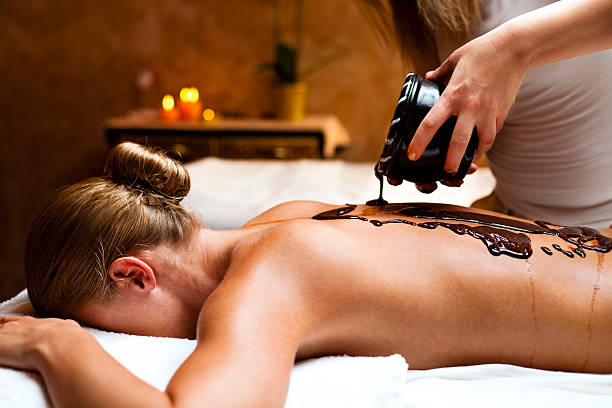 woman having a massage with hot chocolate at health spa.